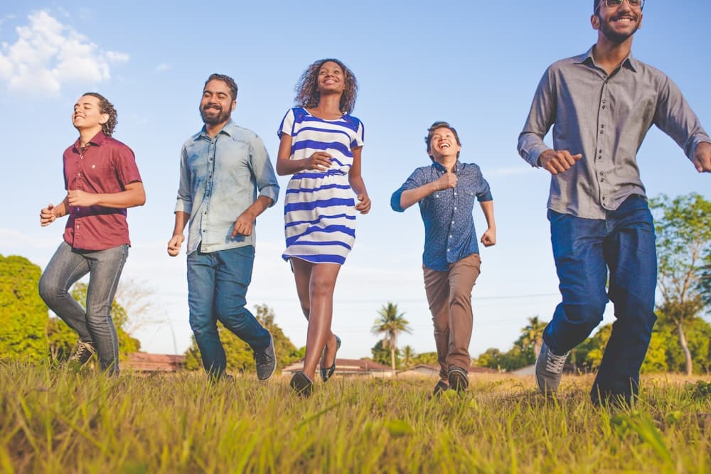 A group of diverse friends and family members walking together outdoors, laughing.