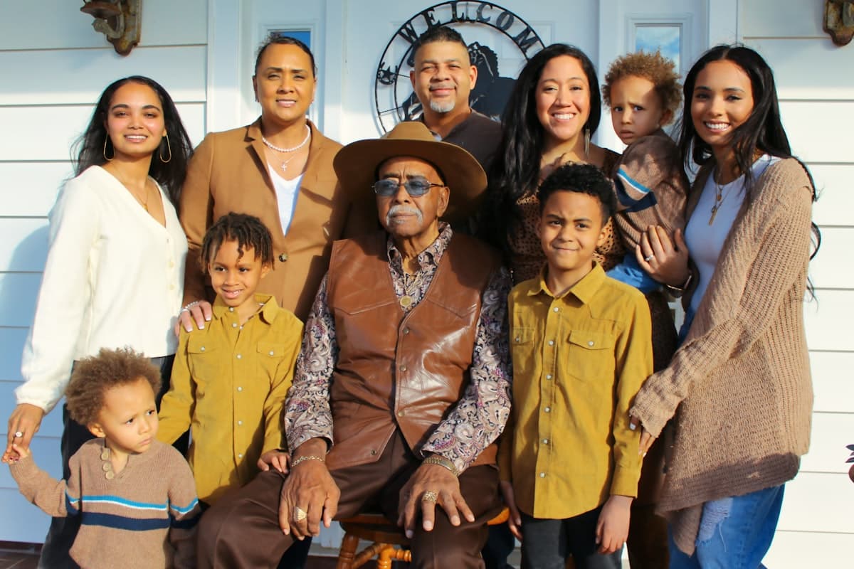 A diverse multigenerational family gathered closely together, smiling.